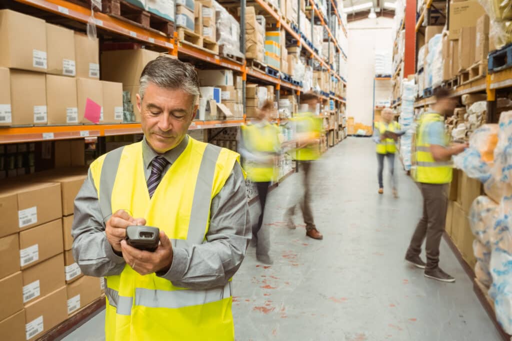 Male warehouse manager checking stock on a handheld device