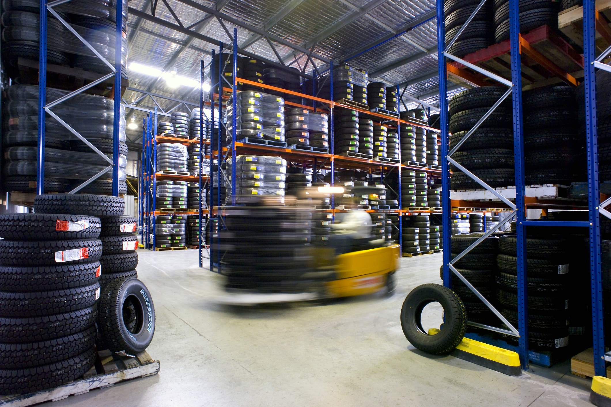 forklift moving tiers in auto warehouse