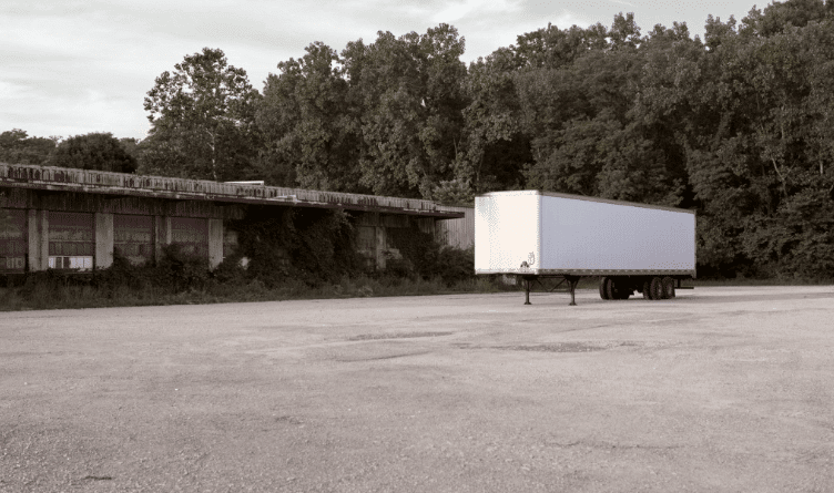 abandoned shipping container in parking lot
