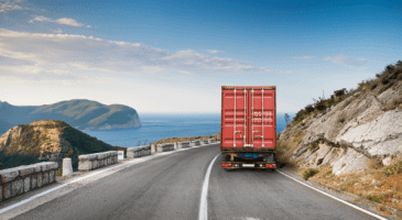 semi truck driving down scenic roadway