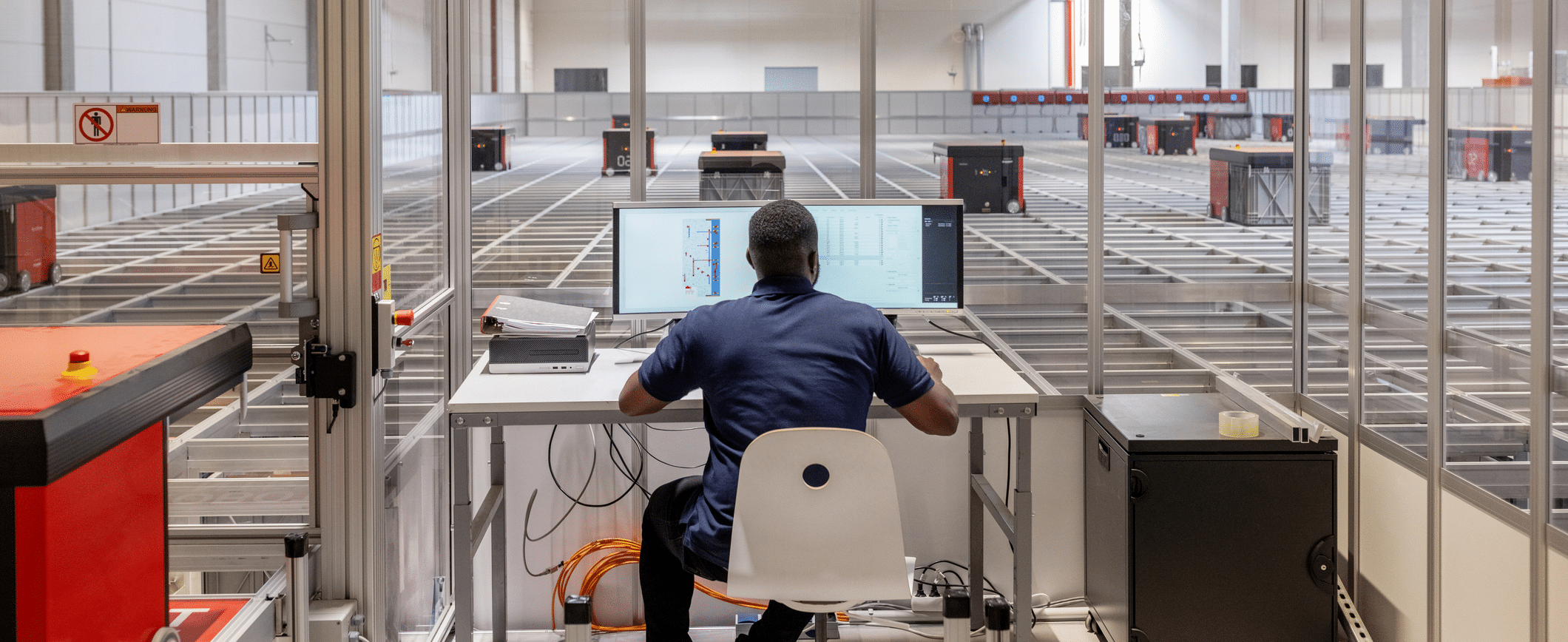 Man operating parcel sorting robot system in warehouse